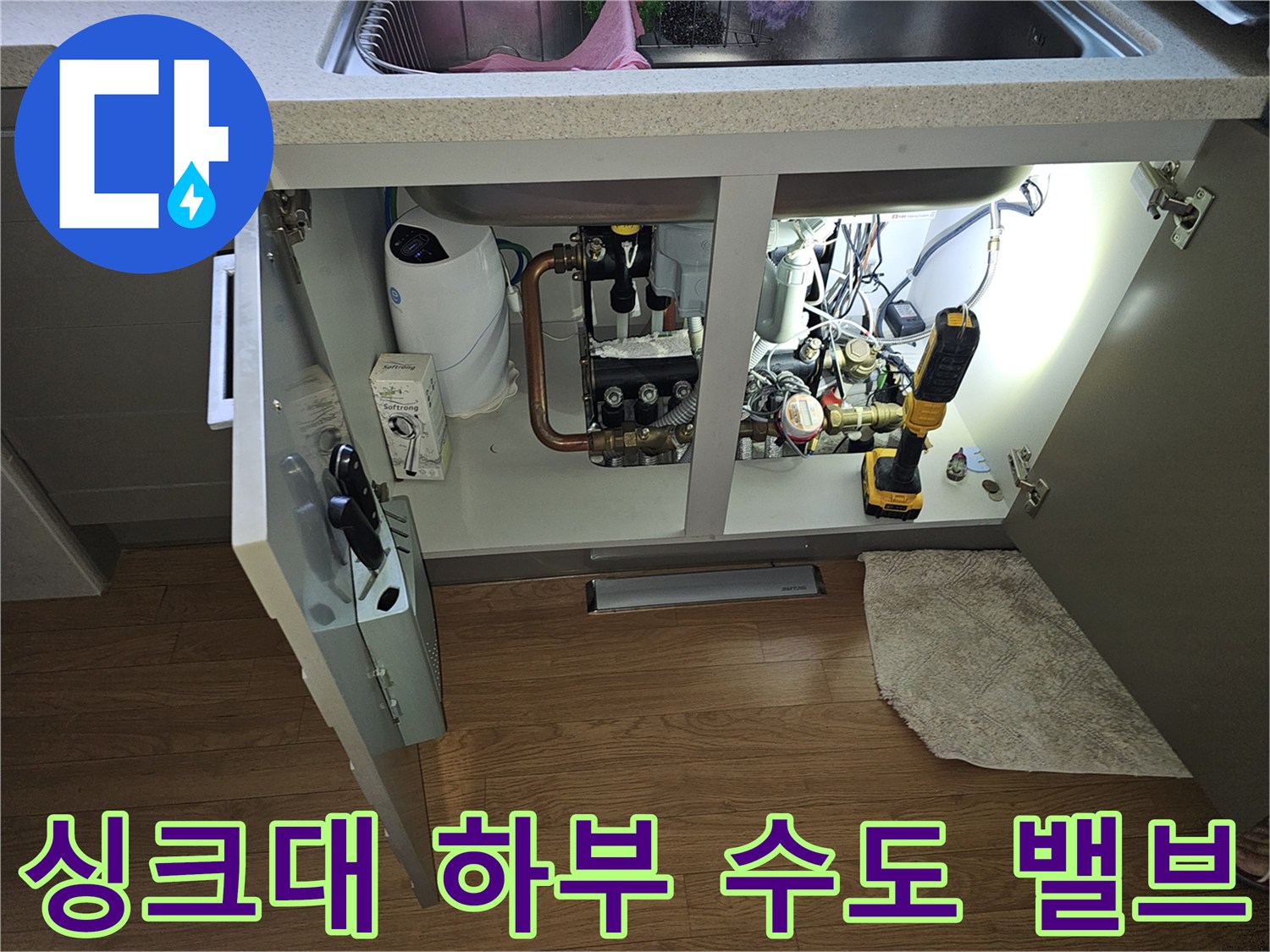 싱크대 하부장 내부에 배치된 수도 부속과 작업 도구