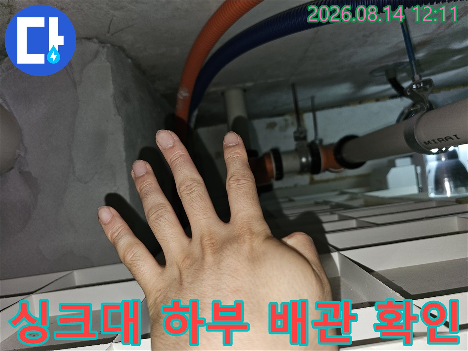 천장에 노출된 주름관과 호스 연결 부위를 손으로 짚으며 점검하는 장면입니다.