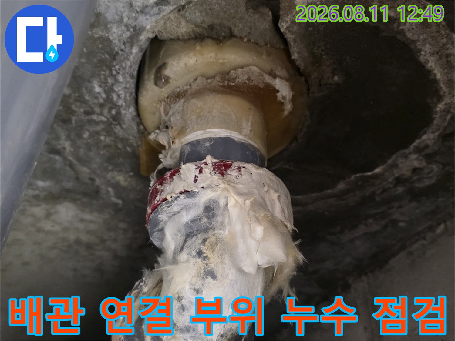 물기가 맺혀 있는 욕조 배수 배관의 결합 부위를 근접 촬영하였습니다.