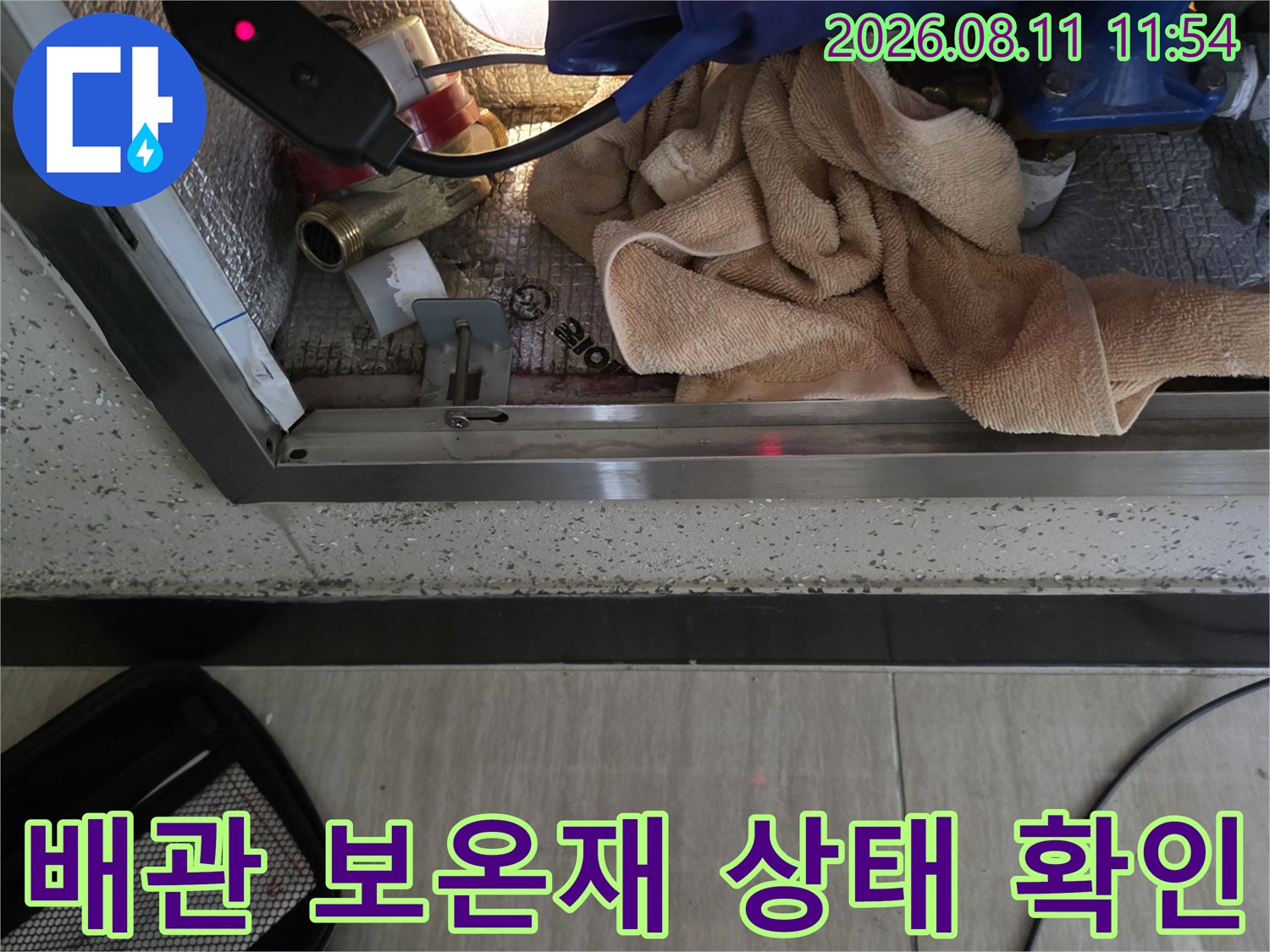 손상된-배관 보온재와 주변 부속의 결함 여부를 정밀하게 관찰하는 모습입니다.