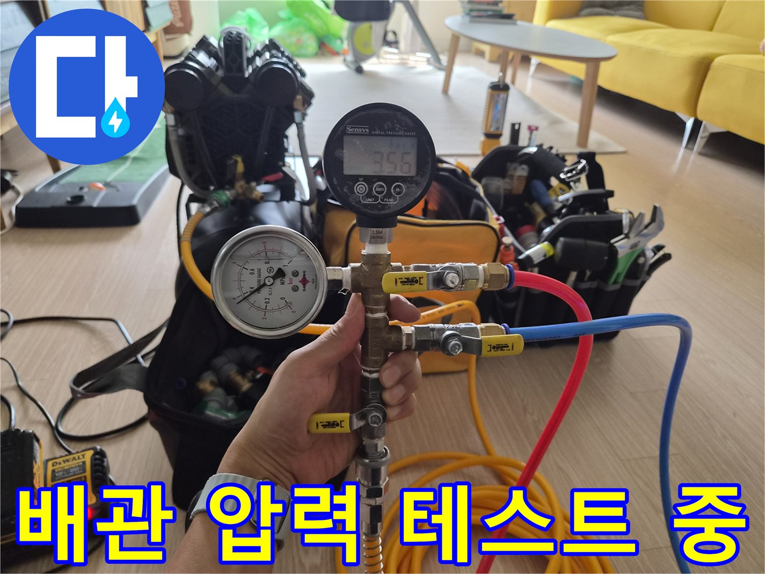 다양한 색상의 호스가 연결된-매니폴드 게이지로 배관 내부를 진단하고 있습니다.