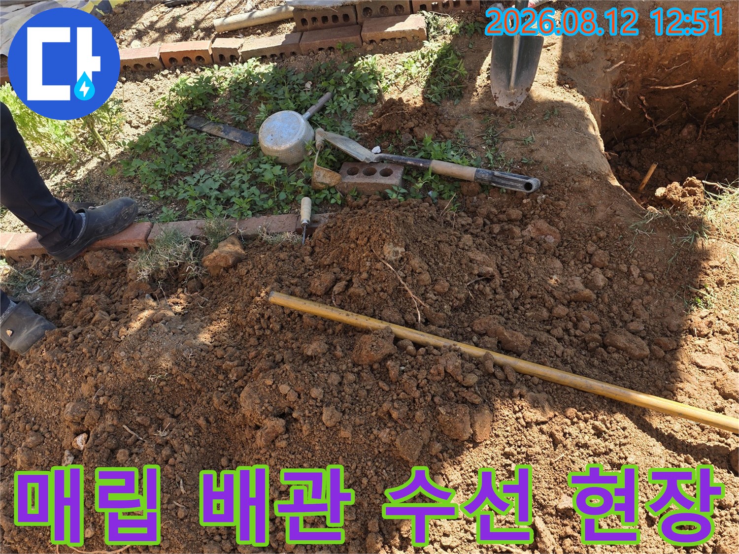 배관 수선을 위해 흙을 파낸-굴착 부위와 작업 도구들