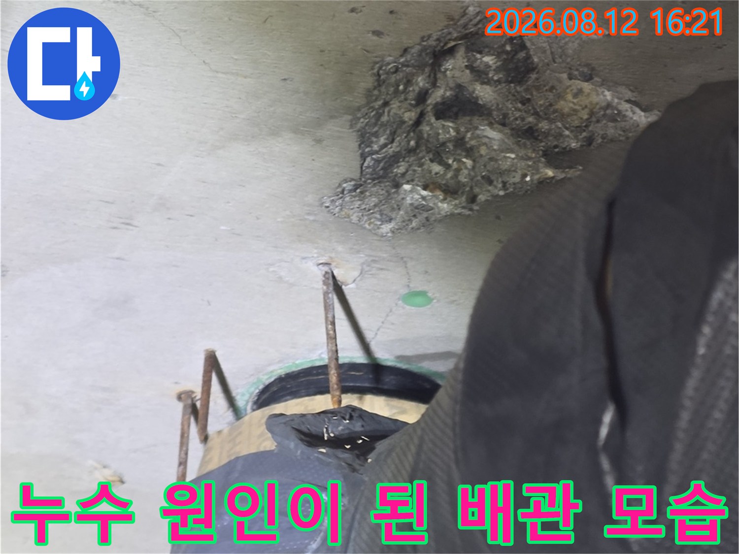 검은색-보호재로-감싸진-배관의-연결-부위에서-누수가-발생한-상태