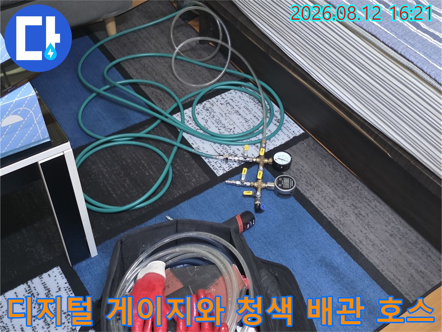 전문 누수 탐지용 디지털 압력 측정기와 붉은색 작업 장갑-배관 점검 준비 상태
