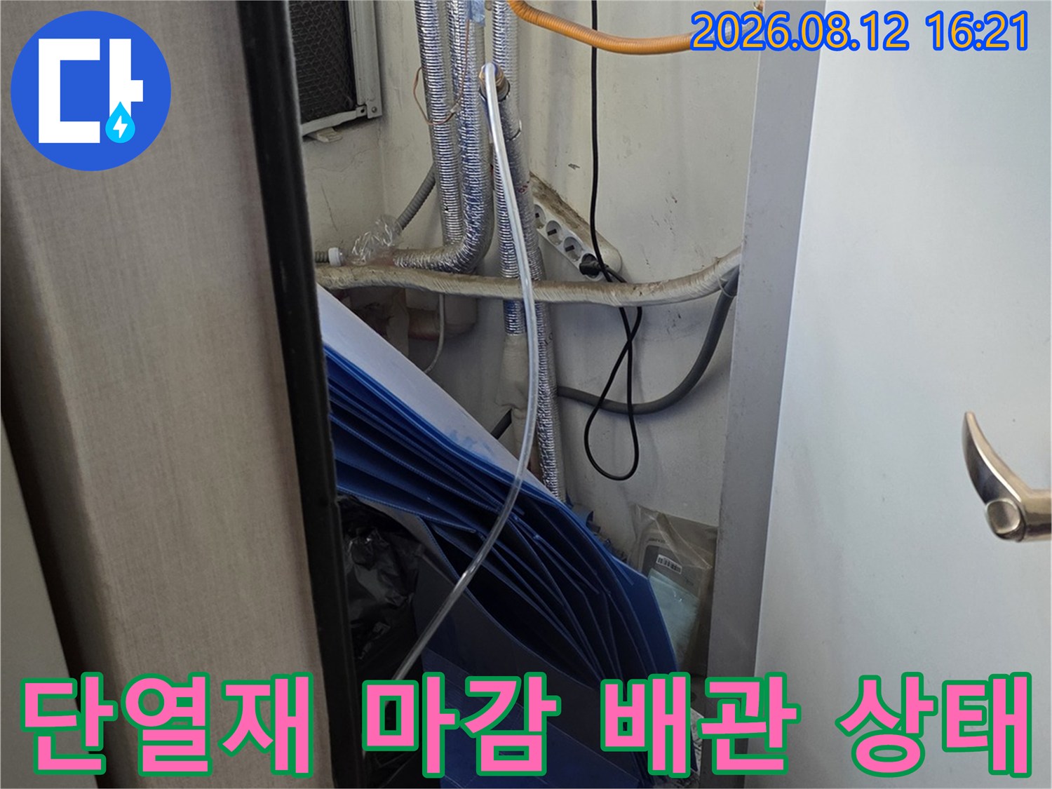 흰색 벽면 배경에 은색 보온재가 씌워진 배관과 노란색 전선이 배치된 구성