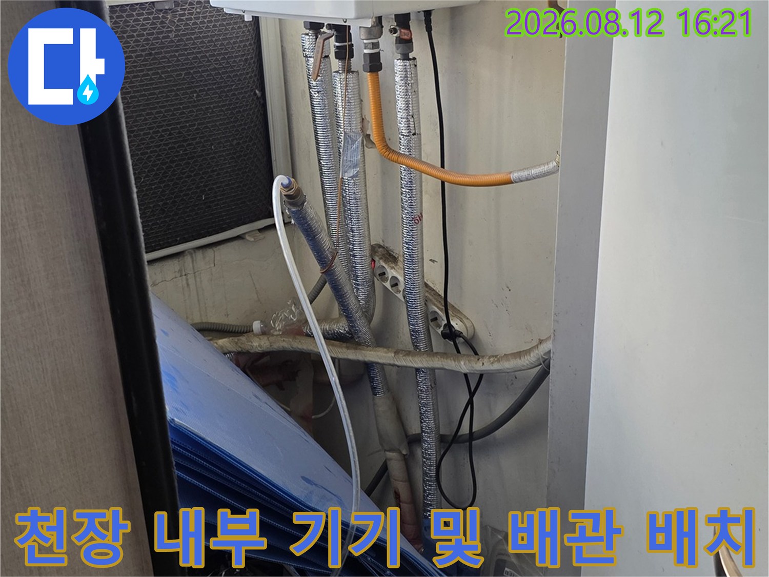 흰색-케이스의-설비-장치와-여러-가닥의-은색-주름관이-연결된-천장-내부-전경