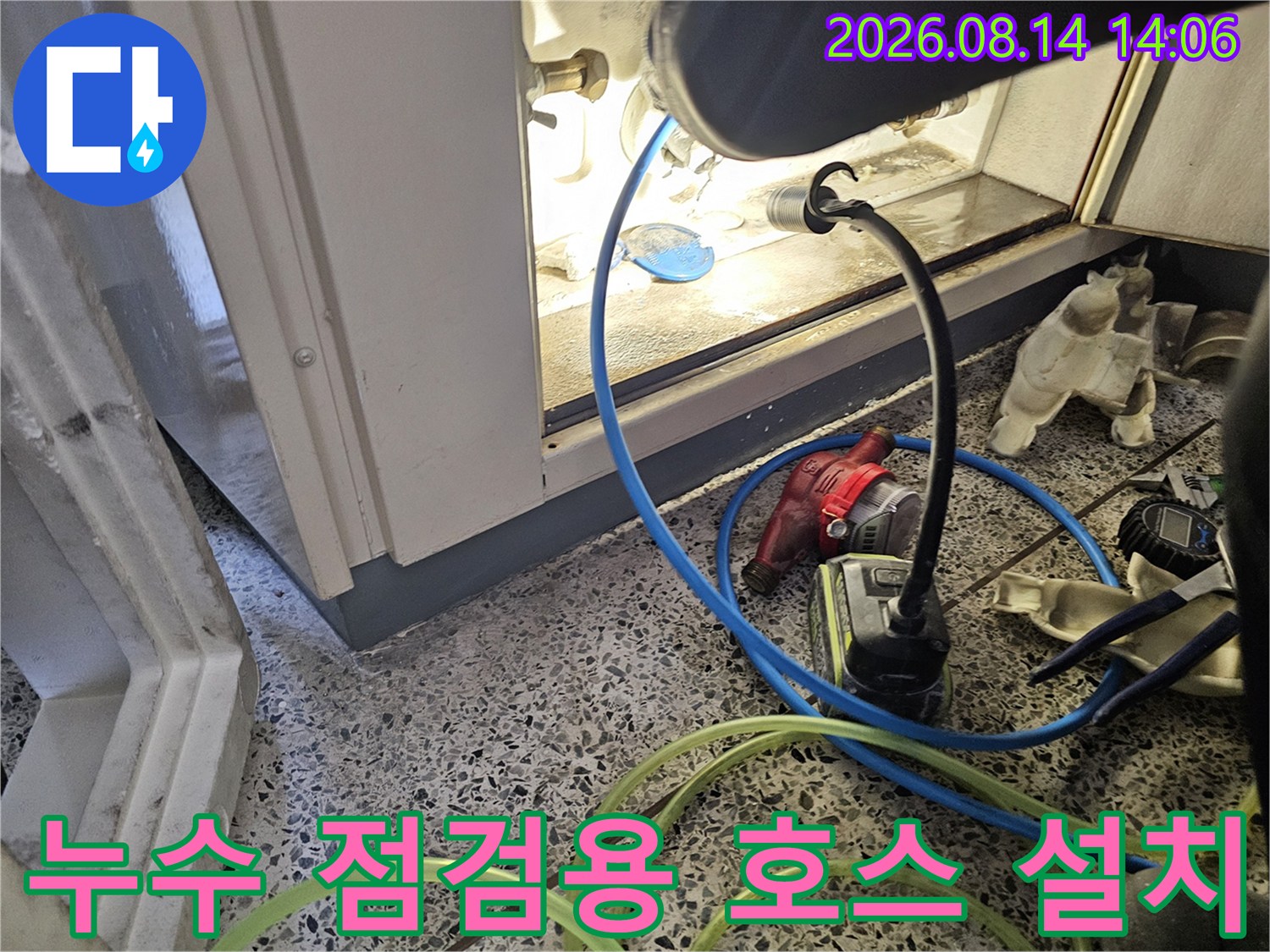 바닥에 배치된 배관 점검용 파란색 호스와 노란색 호스의 모습
