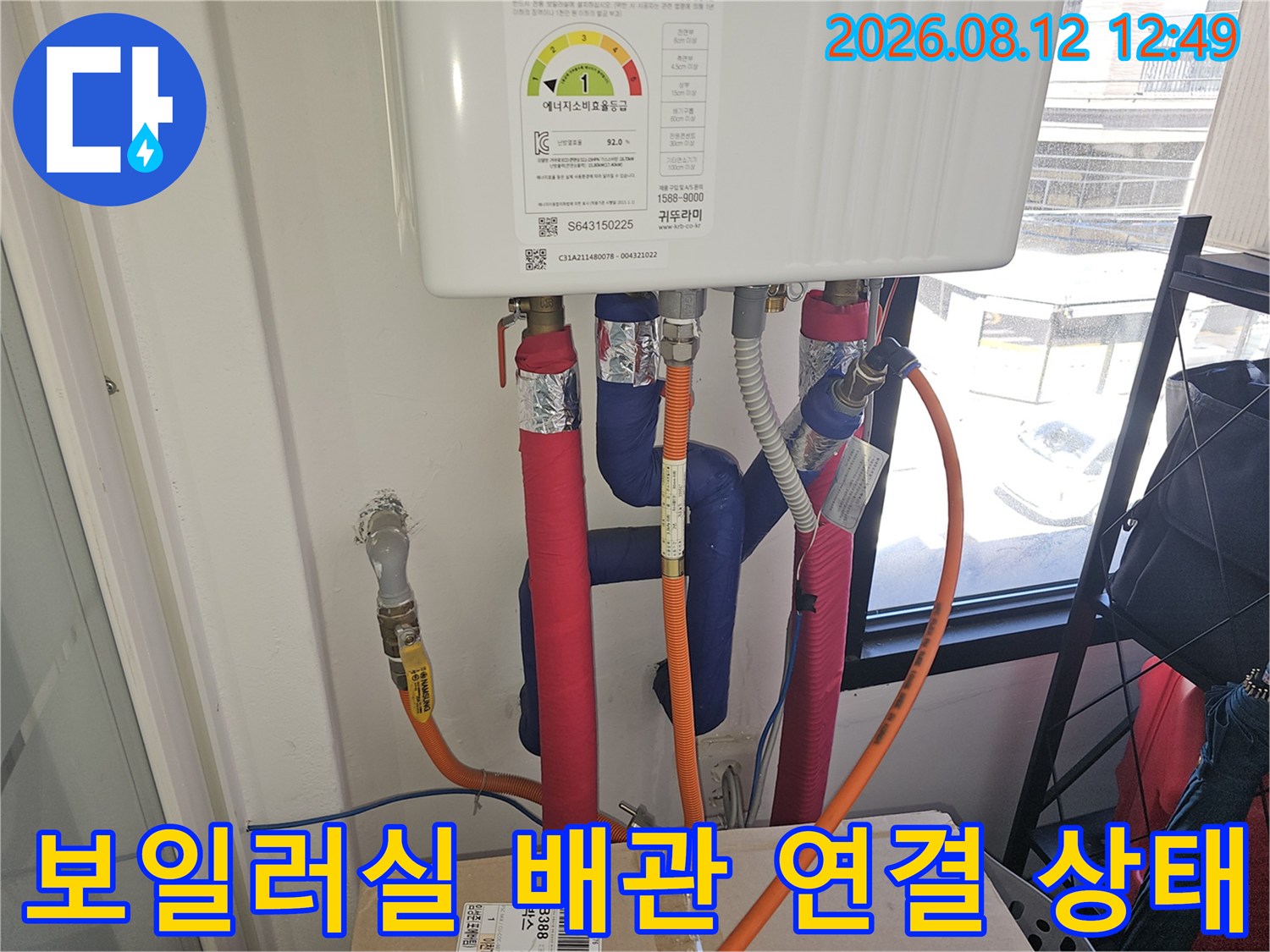 보일러 하단에 설치된 여러 개의 배관과 호스들의 모습입니다.