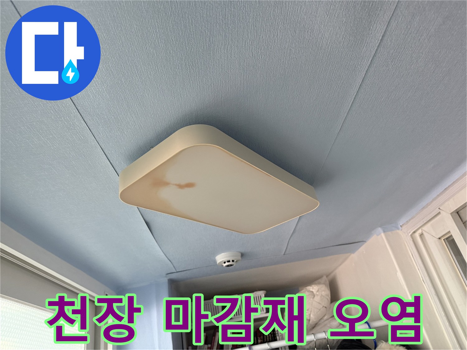 푸른색 천장 마감재와 전등 주변의 누수 오염 부위 설명