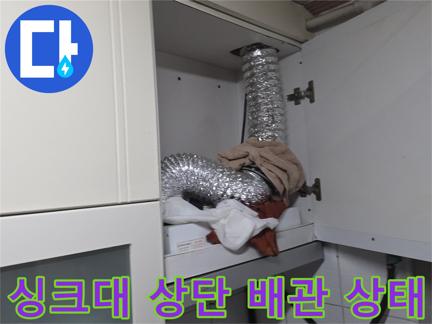 광명 철산동 주방-싱크대 상단에 설치된 은색 자바라 배관과 보수 작업 흔적
