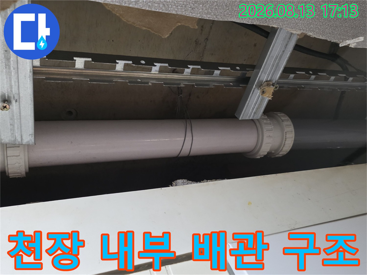 금속 프레임과 함께 배치된 천장 내부 하수 배관의 모습입니다.