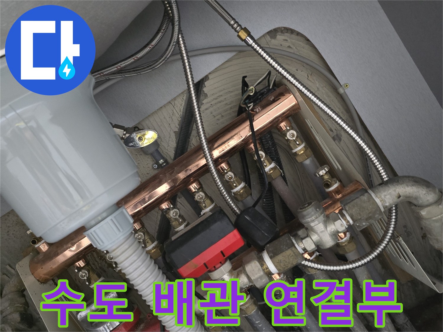 금속 재질의 배관과 검정색 호스가 연결된 주방 설비 상세 사진