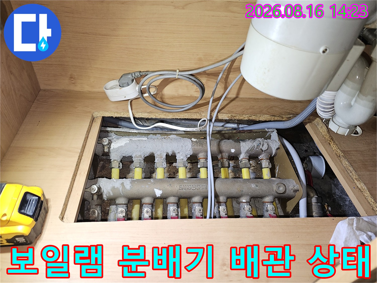 싱크대 아래 보관된 보일러 분배기와 연결된 여러 개의 배관들