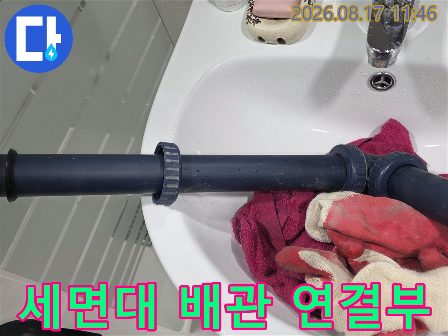 세면대 밑에 설치된 짙은 회색 배수 파이프와 트랩 부위