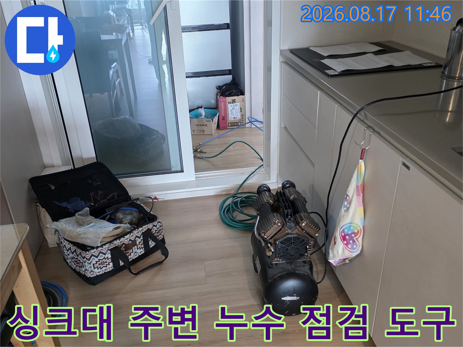 주방 싱크대 밑에 놓여 있는 배관 점검용 압력계와 각종 장비