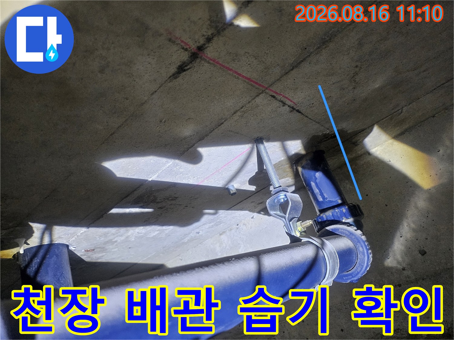 화장실 천장 파란색 배관 주변의 젖은 슬라브 표면 점검