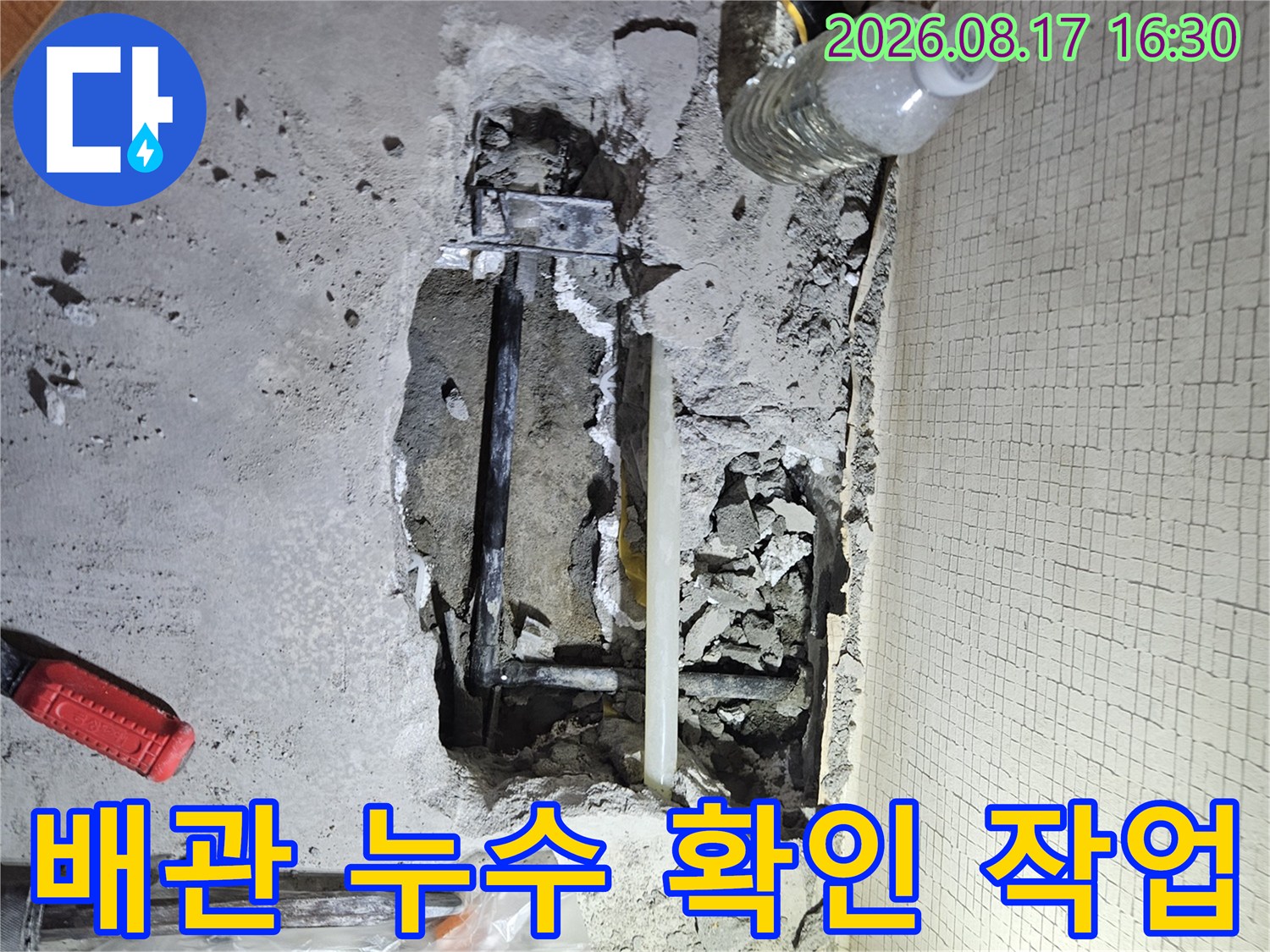 바닥 굴착 부위-드러난 배관과 주변의 파쇄된 콘크리트 조각들