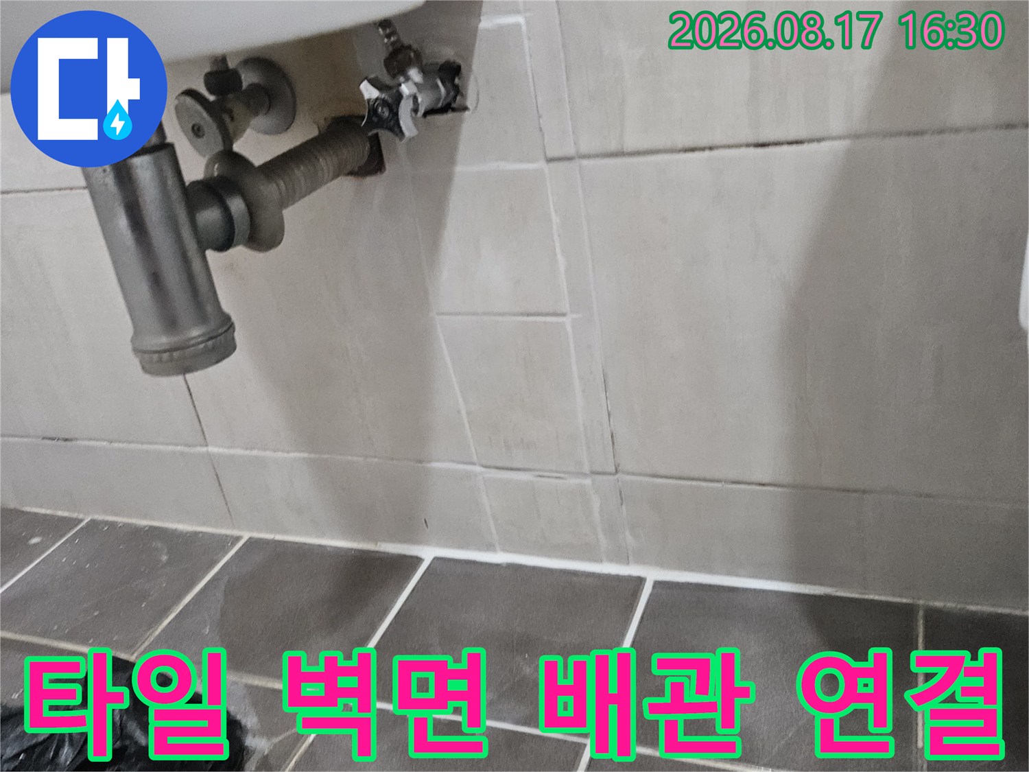 욕실 타일 벽면에 설치된 세면대용 앵글밸브와 급수 배관입니다.