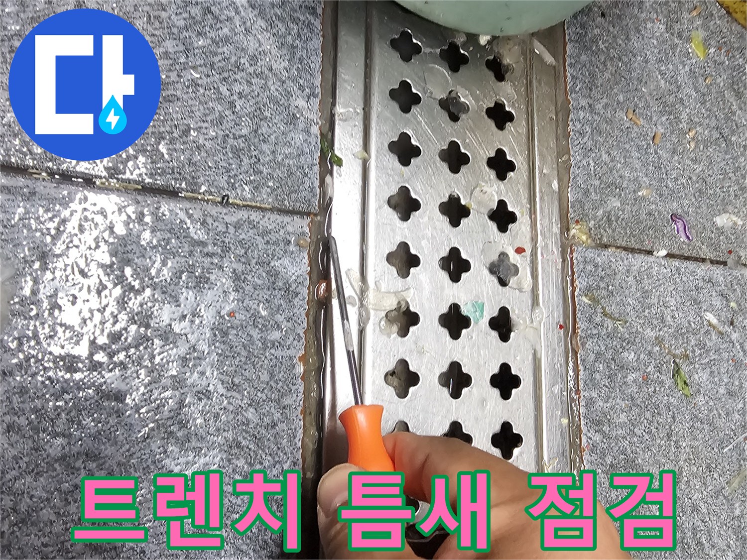 스테인리스 배수 트렌치 사이의 빈 공간을 도구로 확인하는 장면