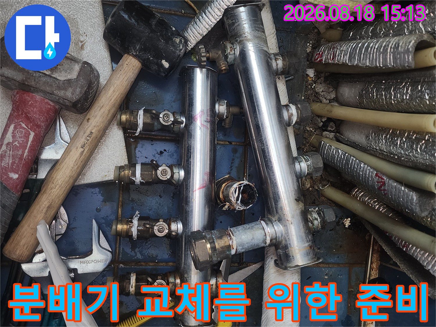 망치와 공구들이 놓여 있는 배관 분배기 해체 작업 현장입니다.