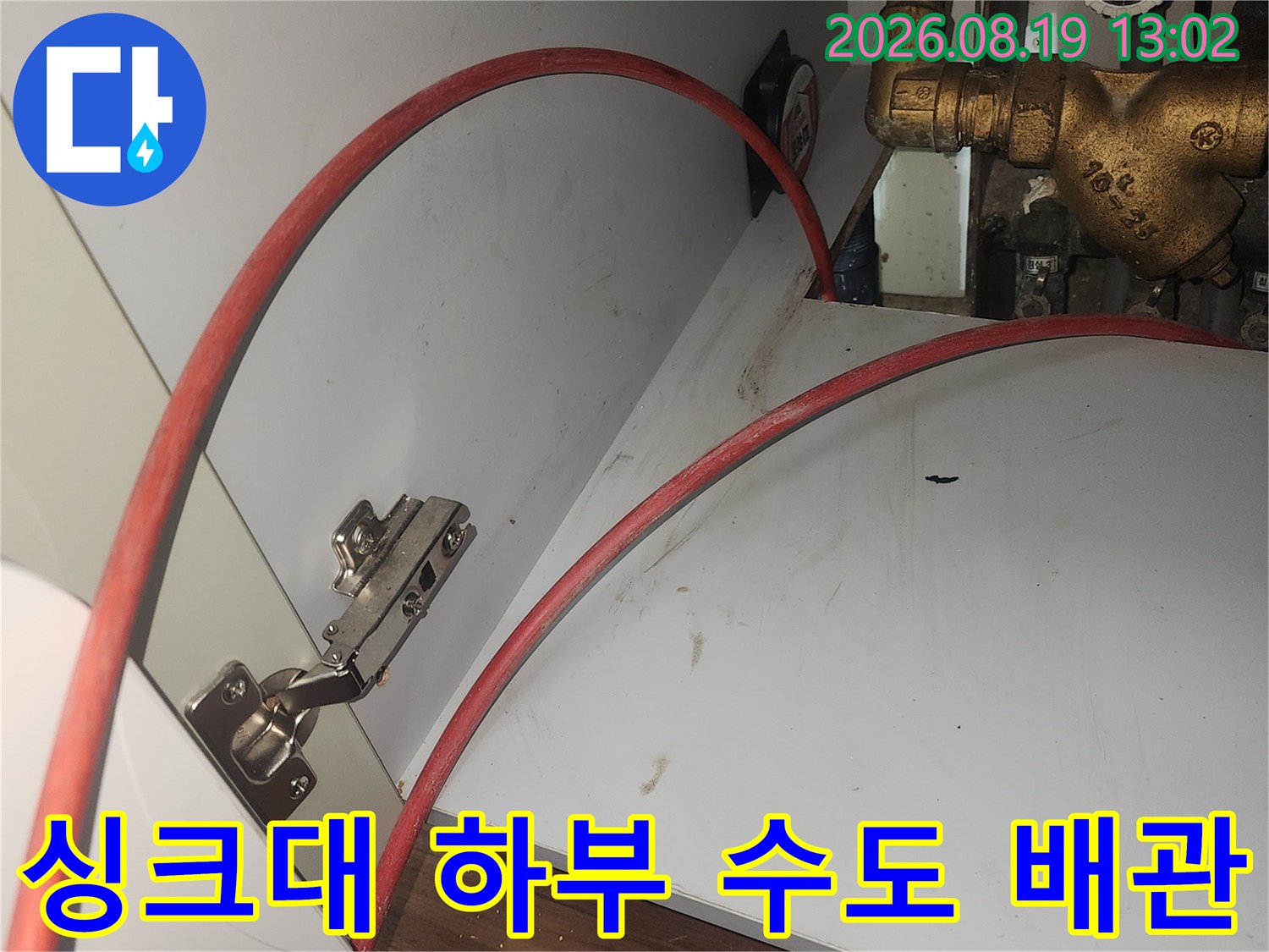 싱크대 밑 금속 소재의 수도 밸브와 연결된 호스 사진