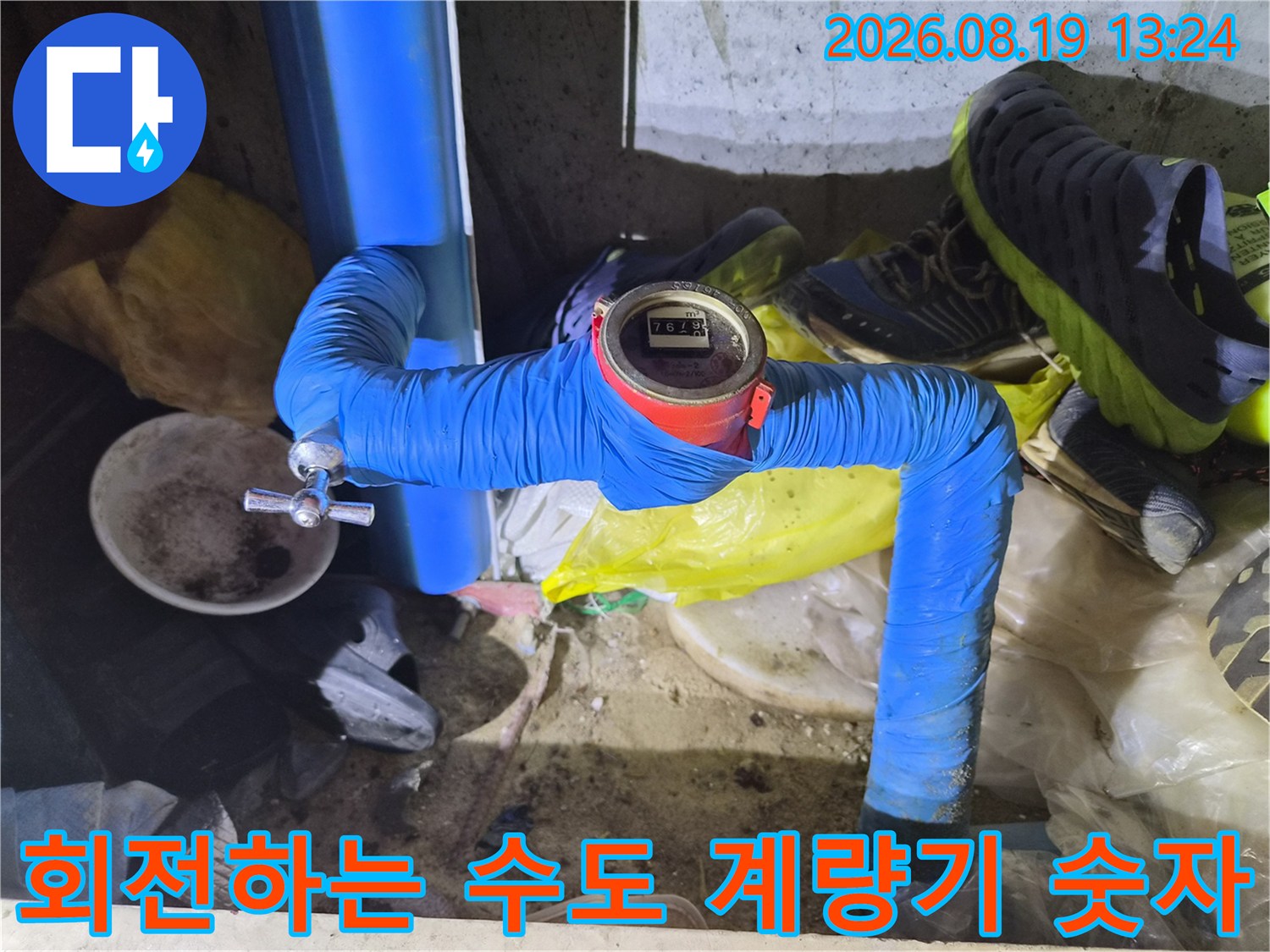 파란색 보온재 배관과 움직이는 수도 계량기의 근접 촬영