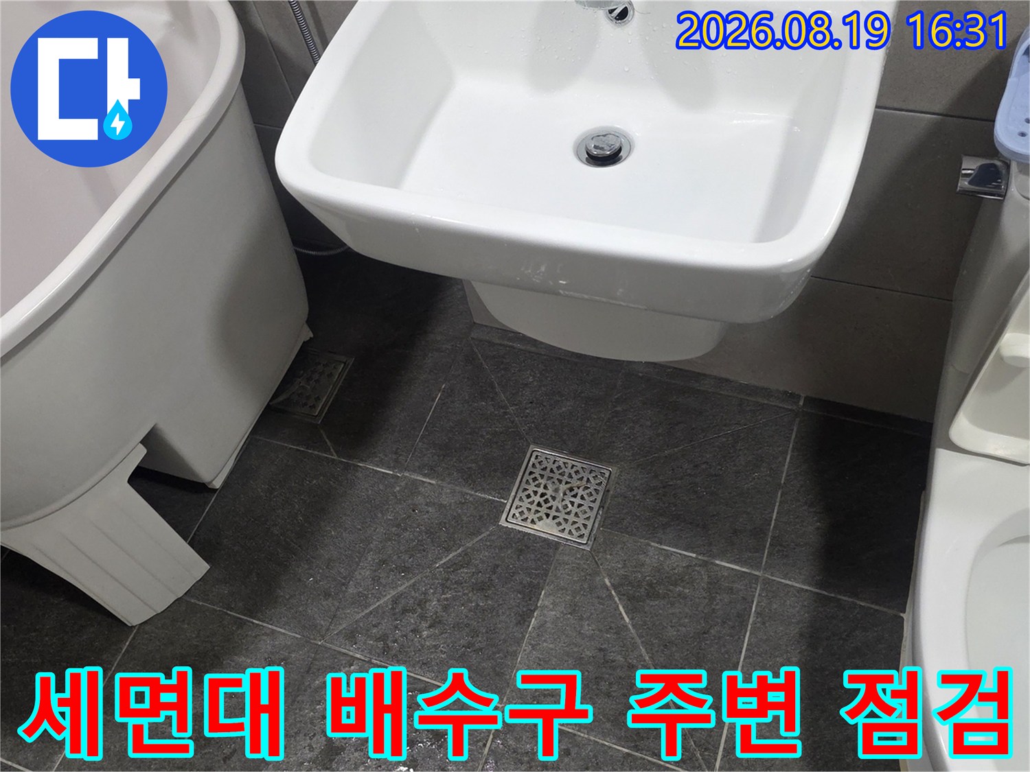 화장실 세면대 하부-배수구와 바닥 타일 접합부를 촬영한 사진