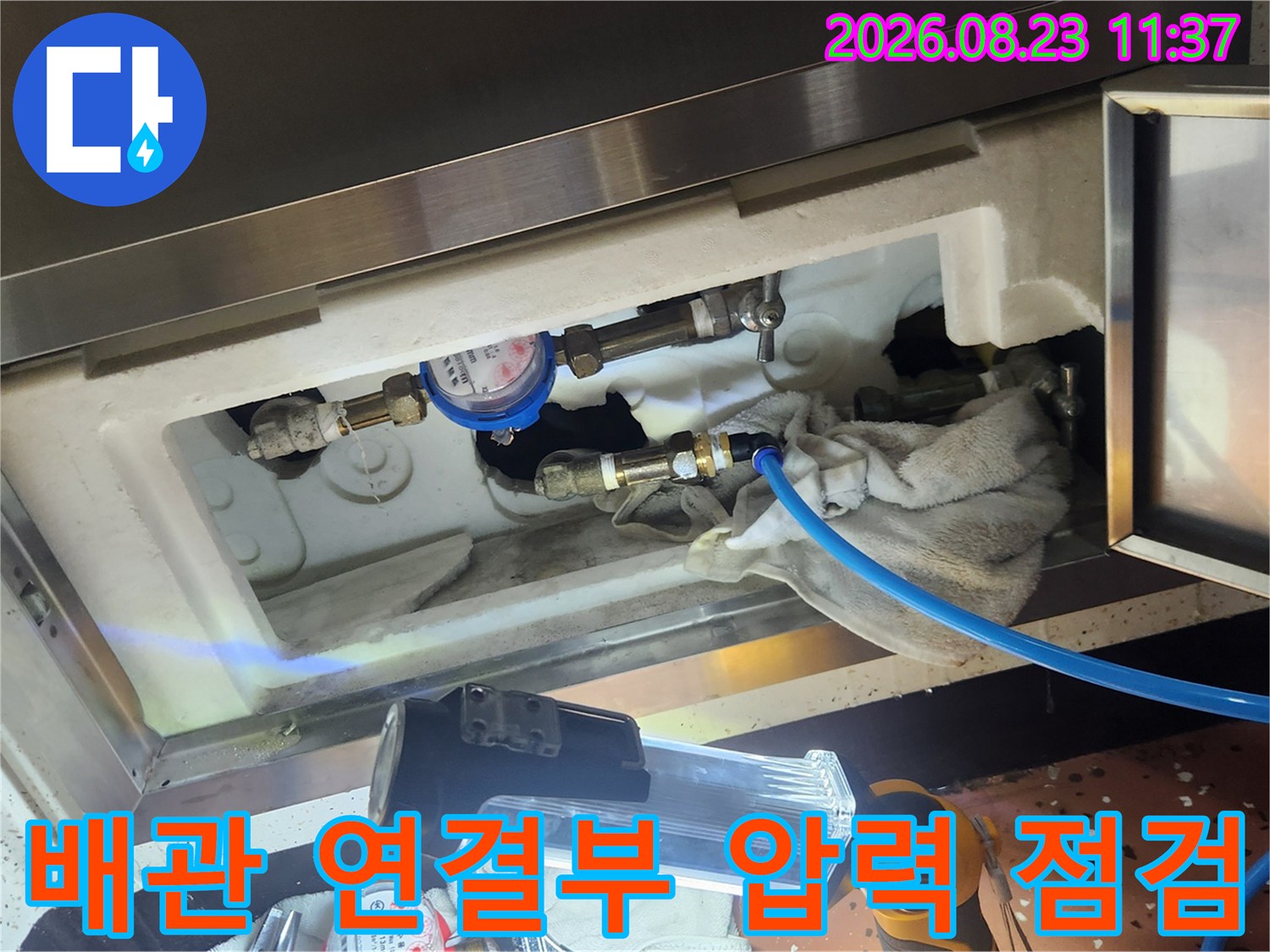 배관 부속에 연결된 파란색 호스와 압력 게이지-보라동 현장