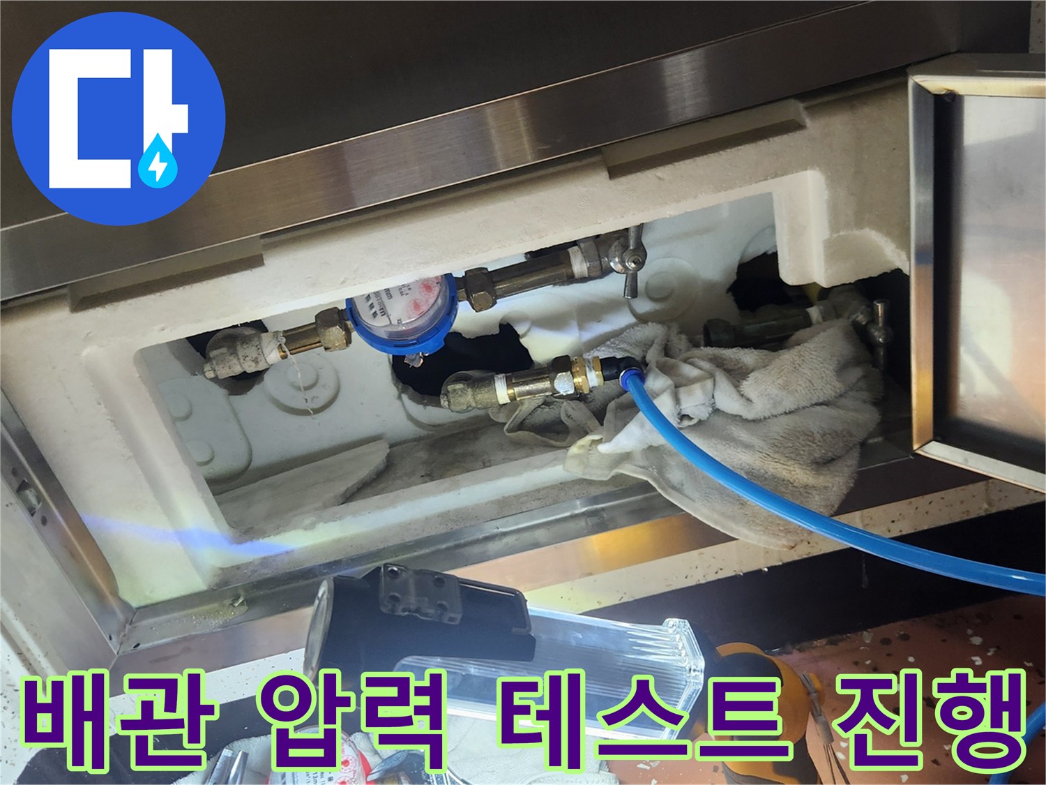 배관 연결 부위에 압력계를 설치하여 공압 상태를 검사하는 엔지니어의 작업 모습입니다.