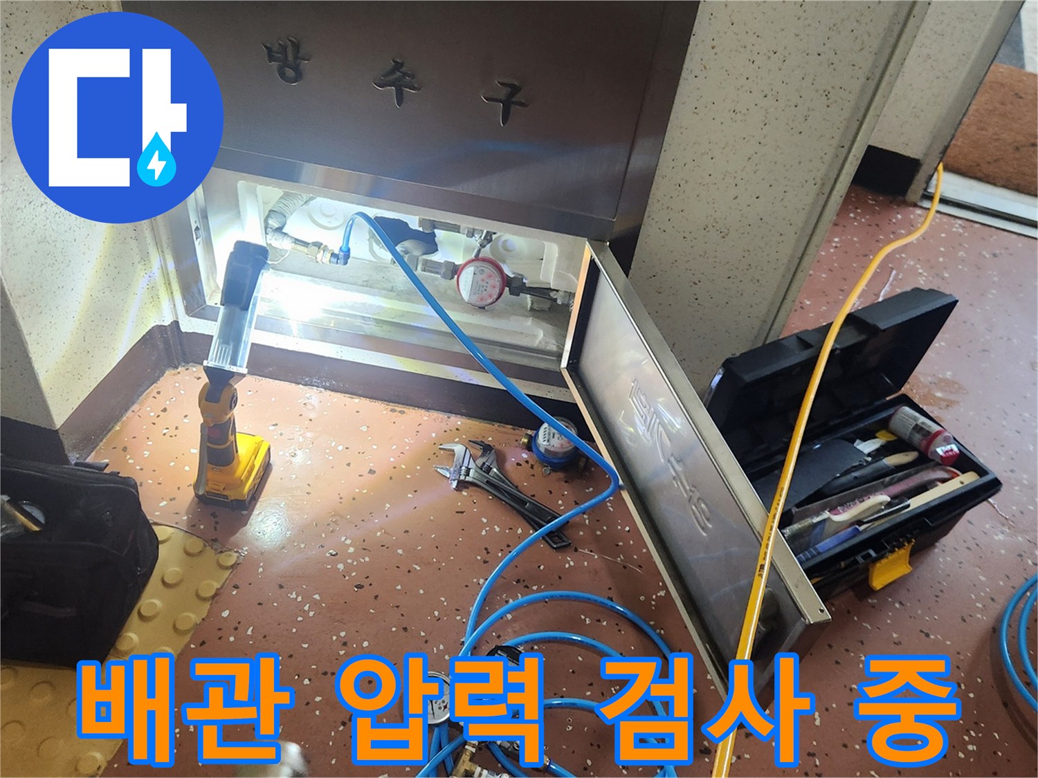 수도 배관의 누수 여부를 확인하기 위해 공압 장비를 연결한 모습입니다.