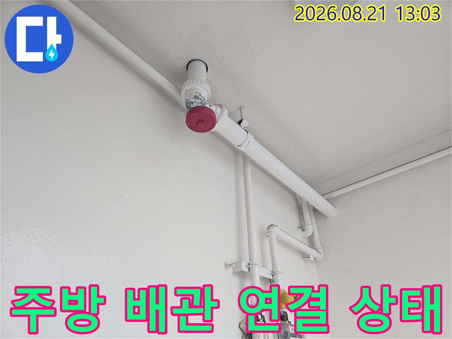 흰색으로 도장된 벽면에 설치된 싱크대 하부 배관 구조입니다.