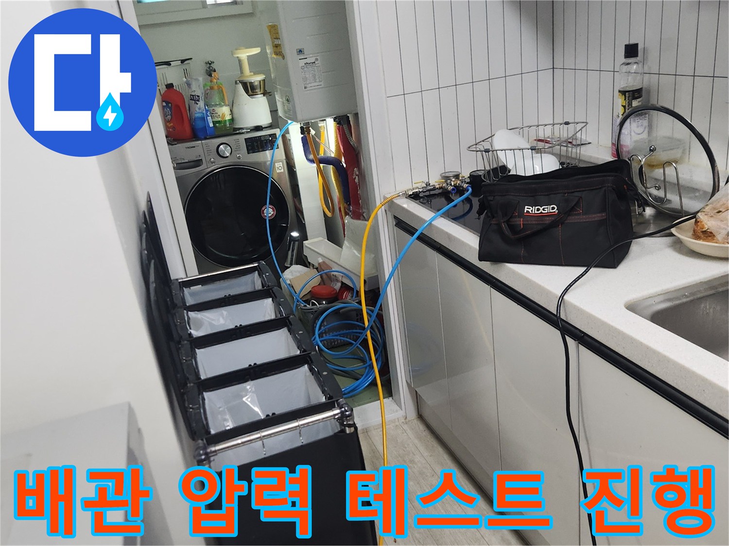 싱크대 하부 배관에 연결된 공압 검사용 장비와 게이지