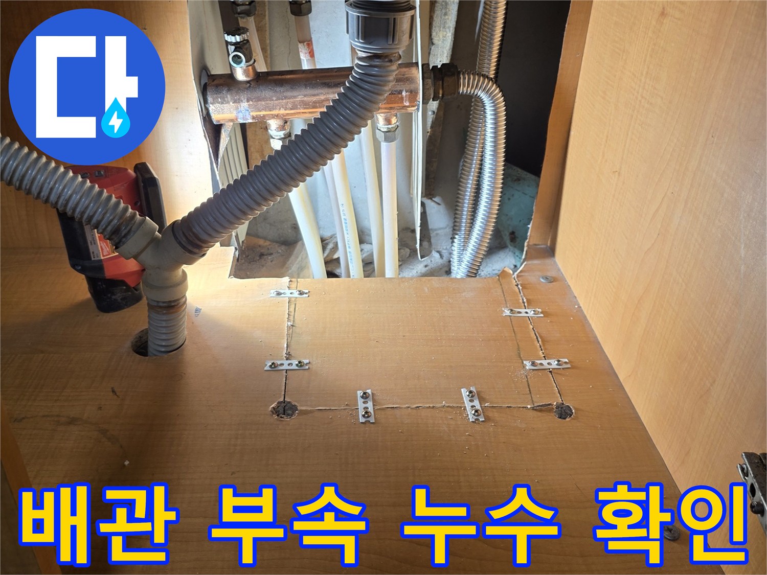 싱크대 하부에 노출된 온수 배관과 주름관의 연결 상태
