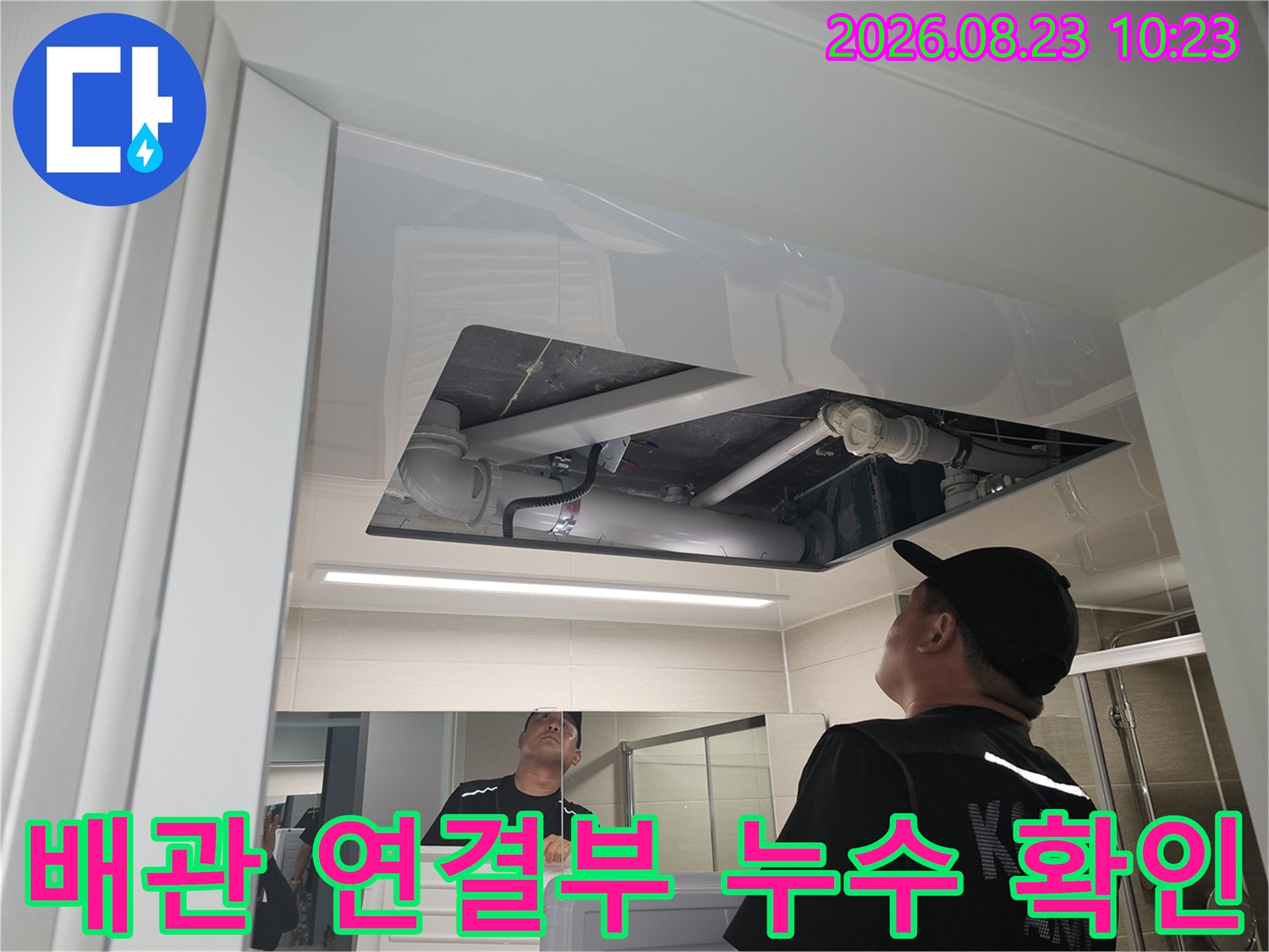 천장 내부 배관의 연결 상태를 상세히 관찰하고 있습니다.