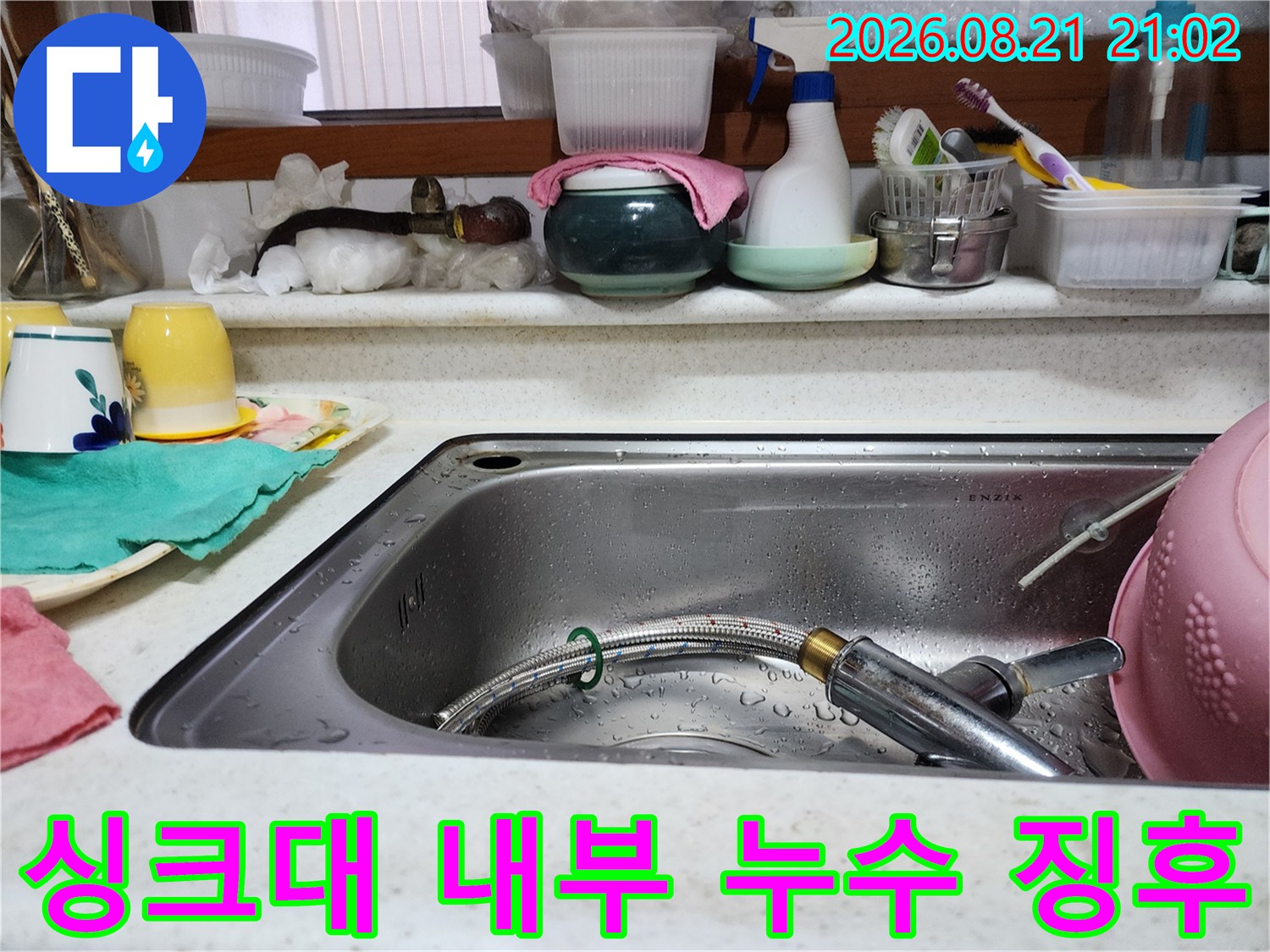 싱크대 배수구와 수전 호스 주변의 습한 상태를 보여주는 사진입니다.