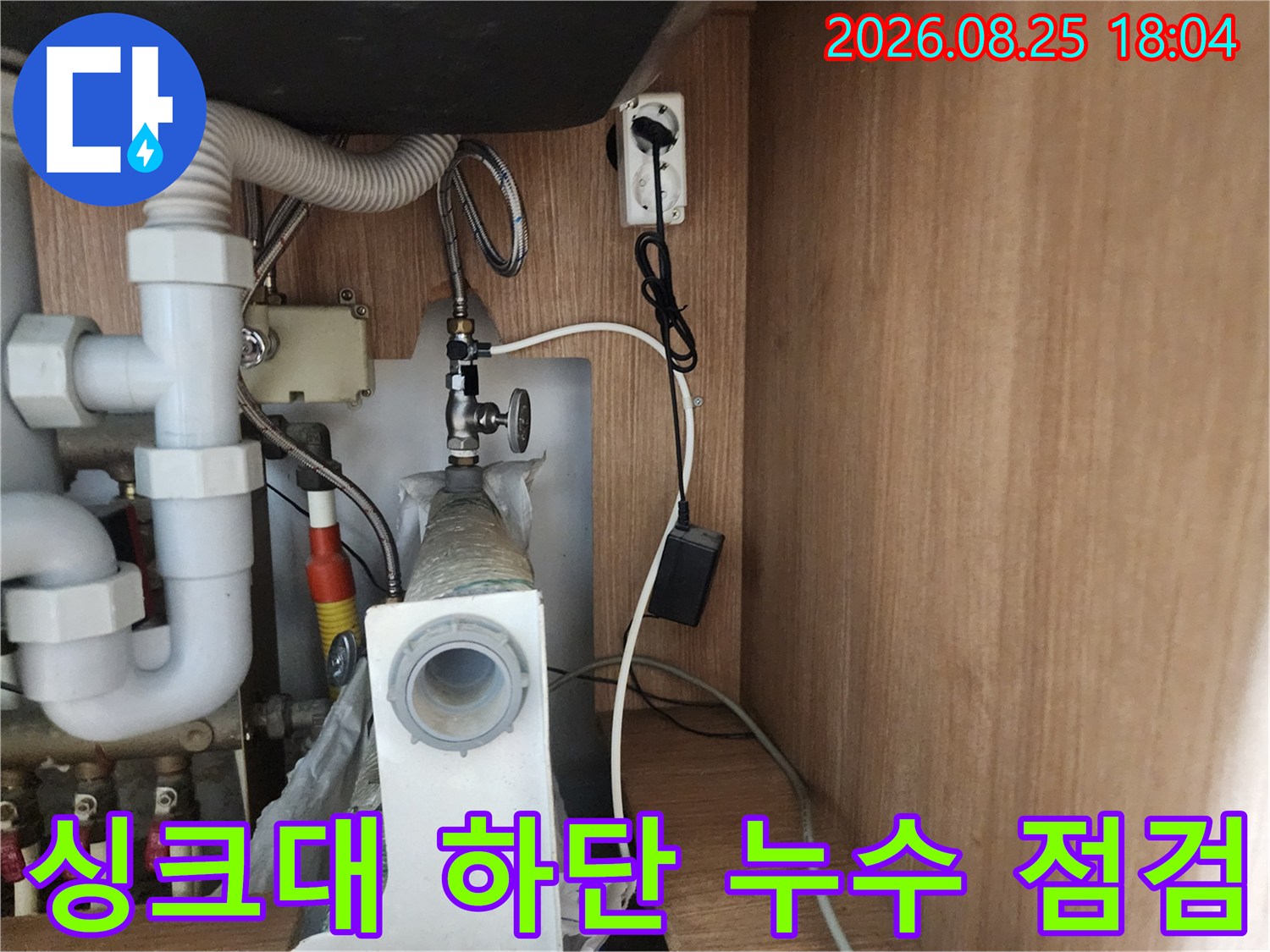 복잡하게 연결된 싱크대 배수 호스와 급수 밸브의 근접 촬영 사진