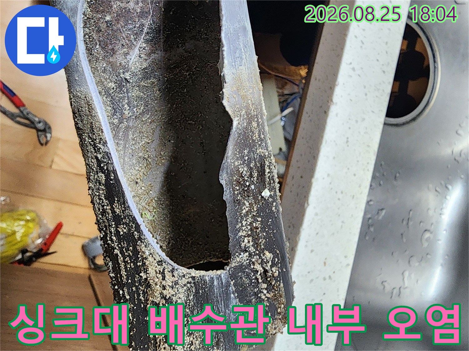 오염된 싱크대 배수관 내부의 찌꺼기와 슬러지 상태를 보여줍니다.