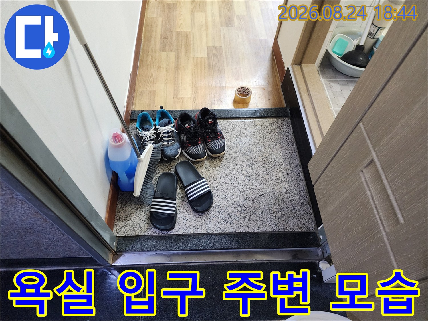 누수 점검 현장의-욕실 앞 신발과 생활 용품
