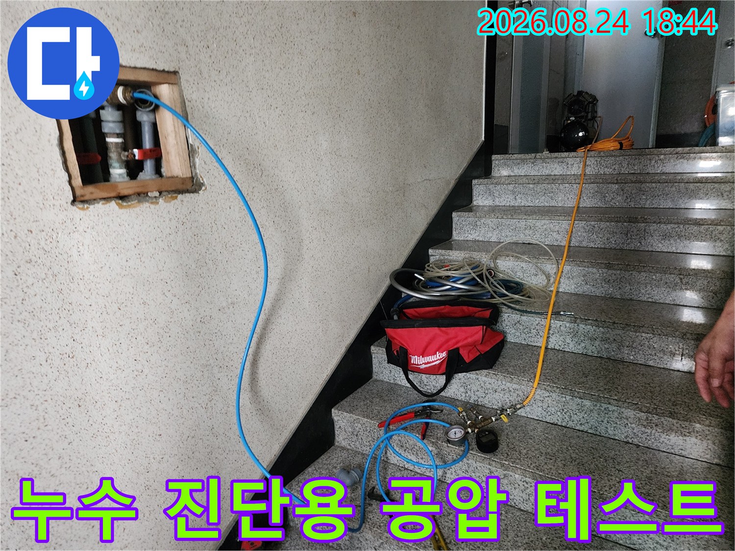 배관 연결 부위에 호스를 연결하여 압력을 가하는 누수 점검 현장입니다.