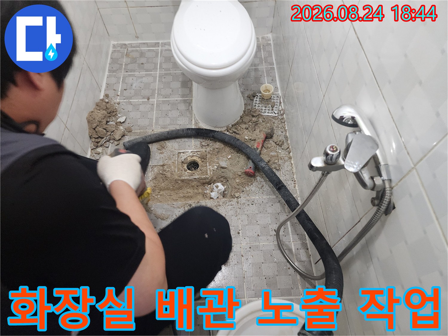 변기 주변 타일을 걷어내고 드러난 배관의 상태를 점검하는 공사 현장입니다.