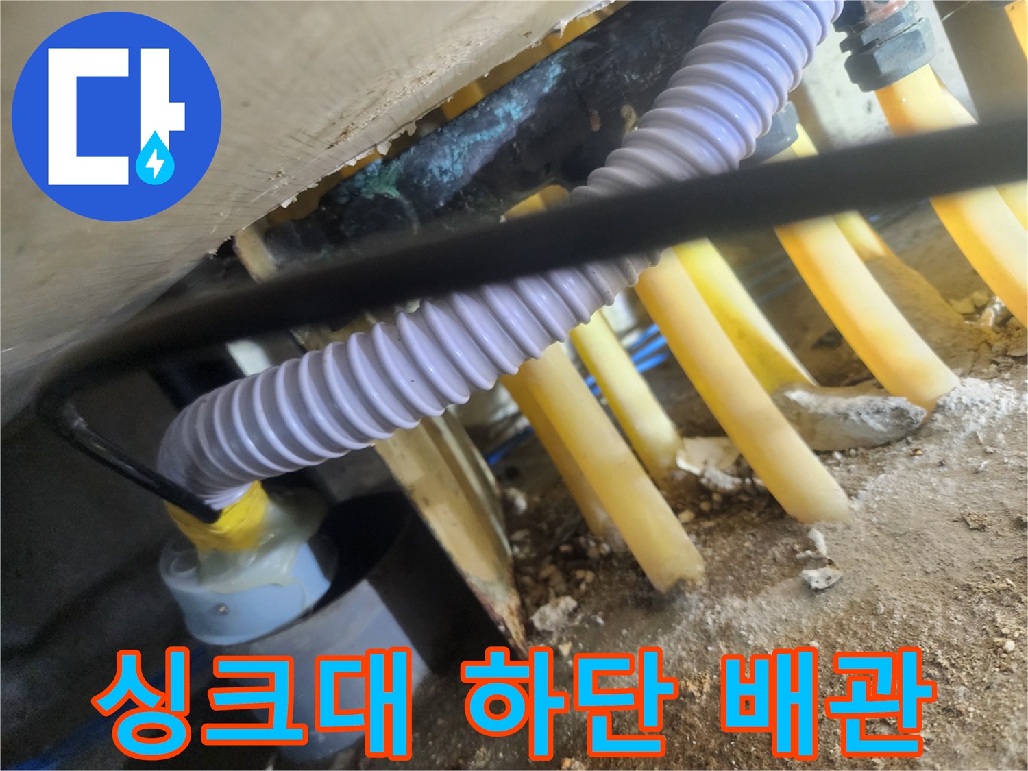싱크대 아래쪽 좁은 공간에 설치된 노란색 배관 라인