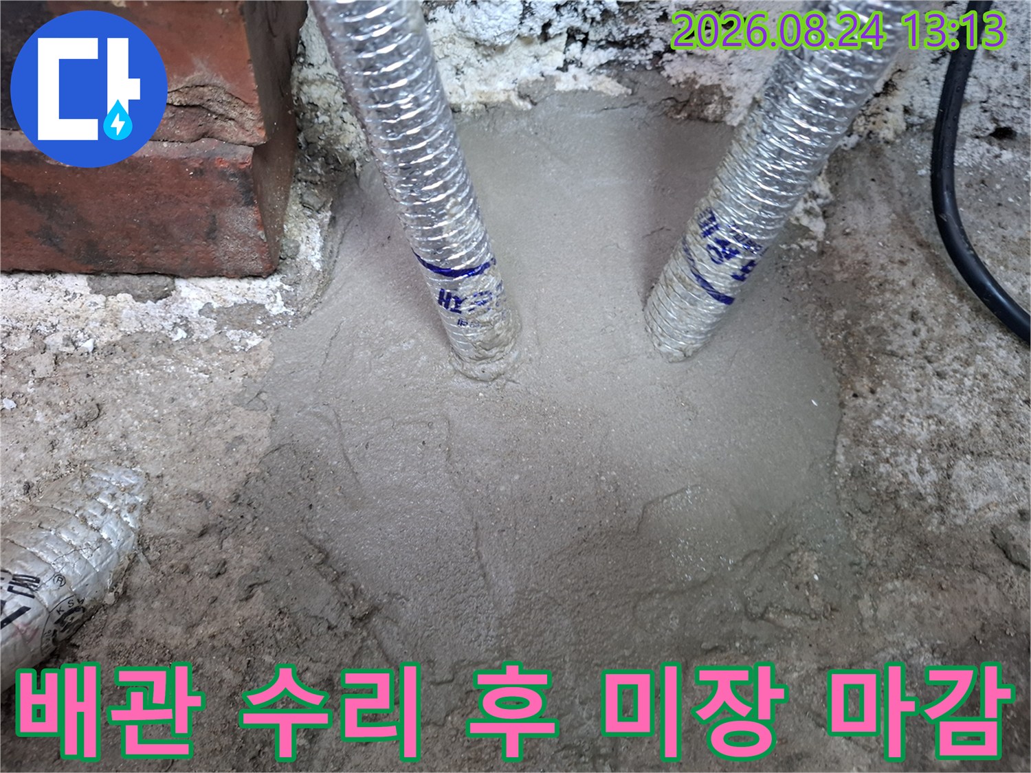 수리가 완료된 배관 주위를 시멘트로 덮어 마무리한 공사 현장입니다.