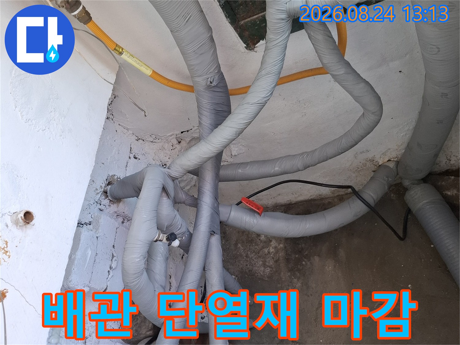 회색 단열재로 꼼꼼하게 감싸져 있는 보일러실 배관 연결 부위의 모습입니다.