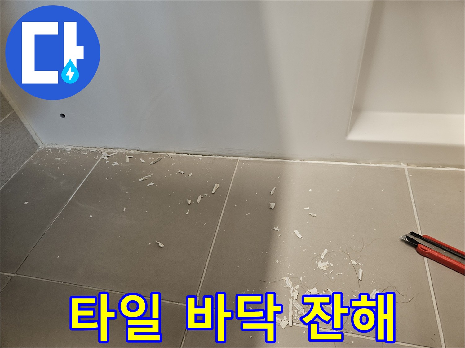 욕실 타일 표면에 흩뿌려진 하얀색 공사 파편