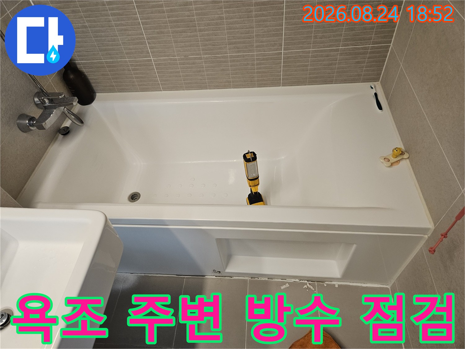 하얀색 욕조와 벽면 타일의 연결 부위를 촬영한 사진입니다