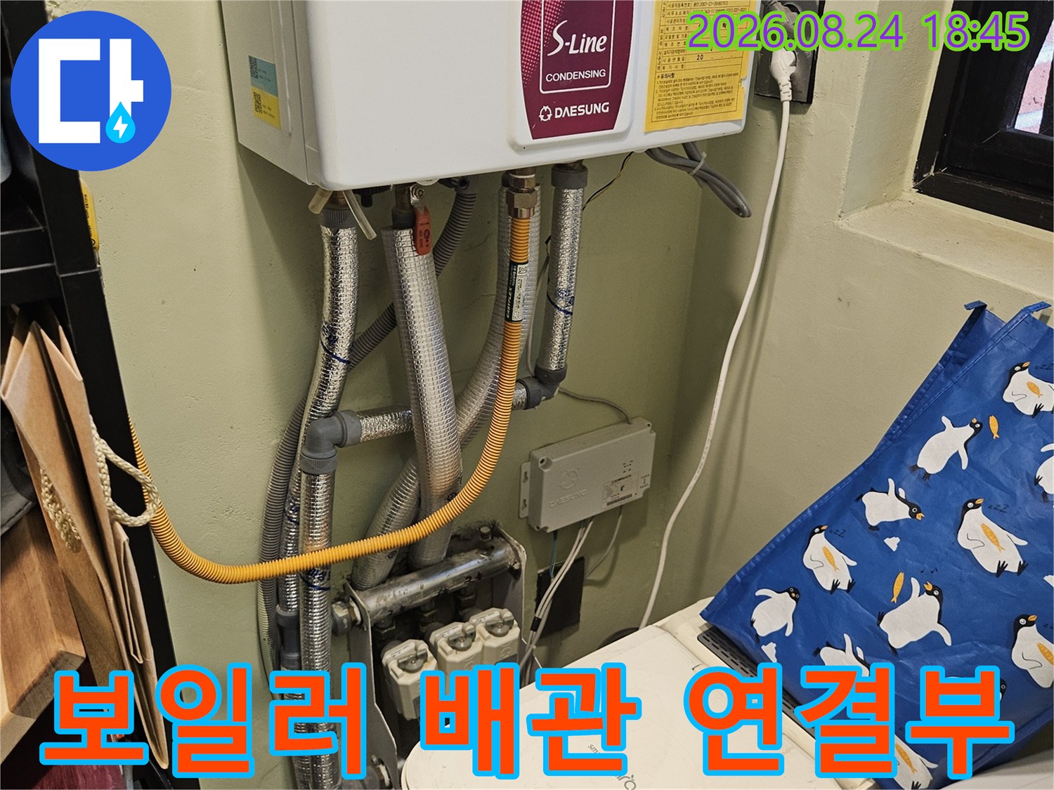 보일러와 세탁기 주변의 배관 및 전기 콘센트 연결 상태를 보여주는 사진입니다.
