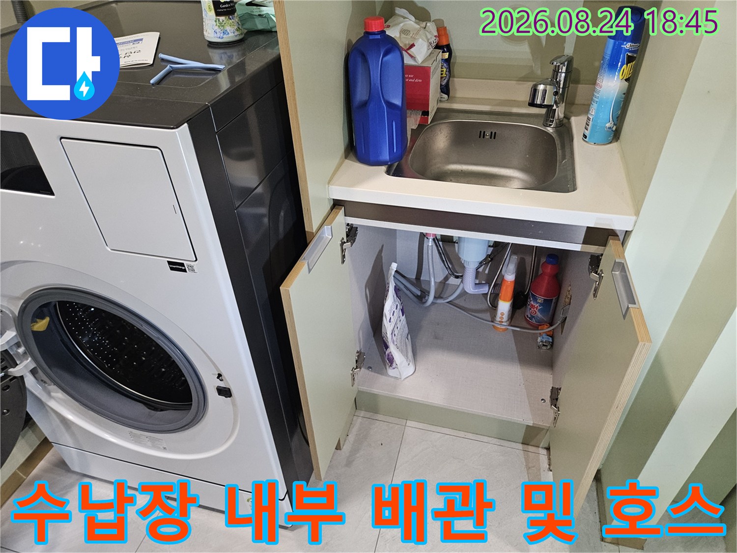세탁실 수납장 안쪽의 수도 연결 부위와 세제 용기들