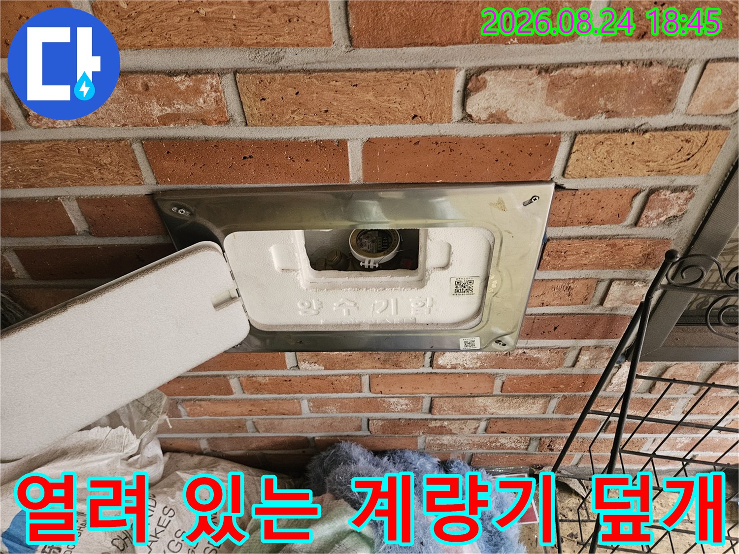 적벽돌 사이 수도 계량기함의 내부 상태를 보여주는 사진입니다.