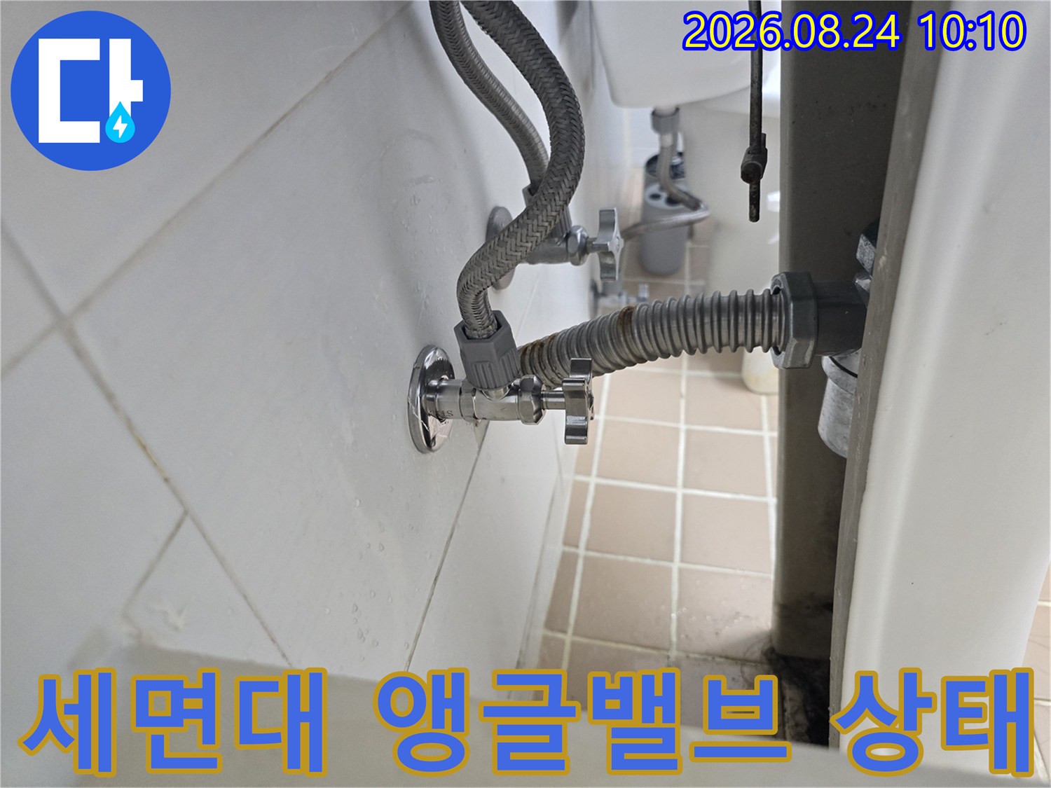 세면대 아래 벽면에 설치된 은색 앵글밸브와 호스 연결부