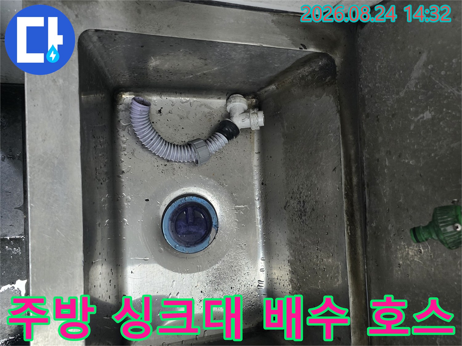 물기가 남아있는 스테인리스 싱크대 내부의 배수 호스 연결부